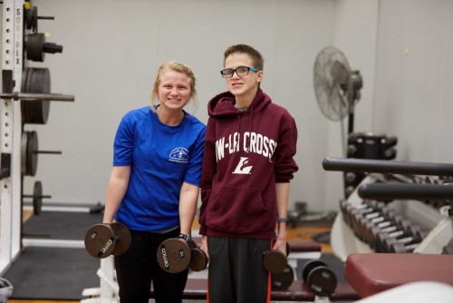 Graduate student lifts weights with Motor Development participant