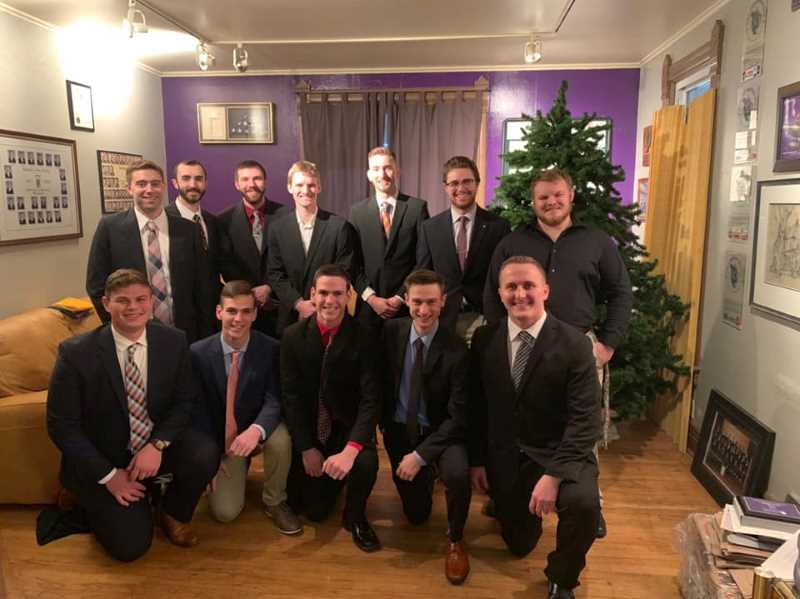 Members of Lamda Chi Alpha posing in suits for a photo.