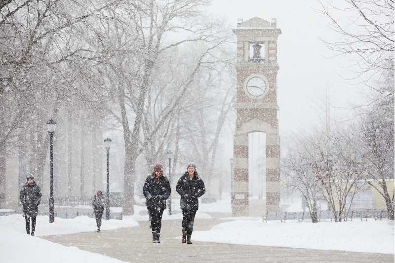 Students outside the clock tower in the winter