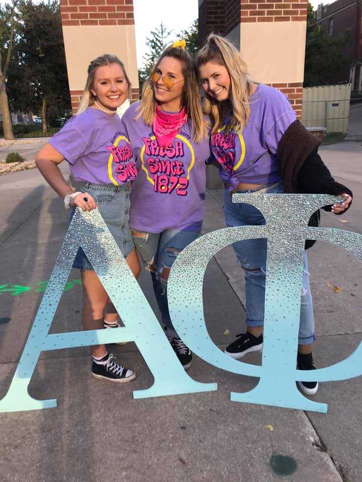 Members of Alpha Phi pose with their giant letters in front of the clock tower, celebrating their 2018 Bid Day.