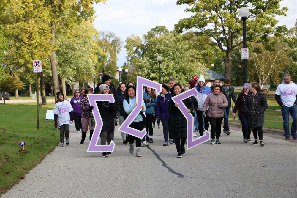 The women of Tri Sigma walk with their giant letters to spread awareness and raise money for their national philanthropy-- The March of Dimes. 