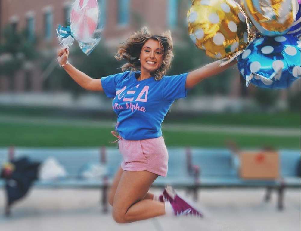 An Alpha Xi Delta woman jumps for joy during the 2019 Bid Day celebration.