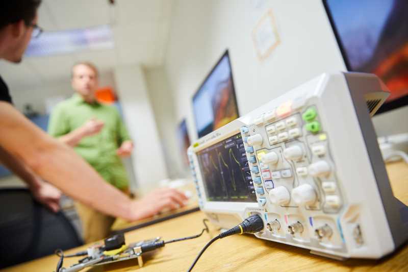 Student and a professor working on a project in a computer lab.