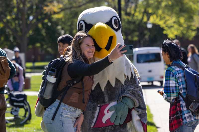 A student takes a selfie with Stryker Eagle during One Day for UWL 2023.