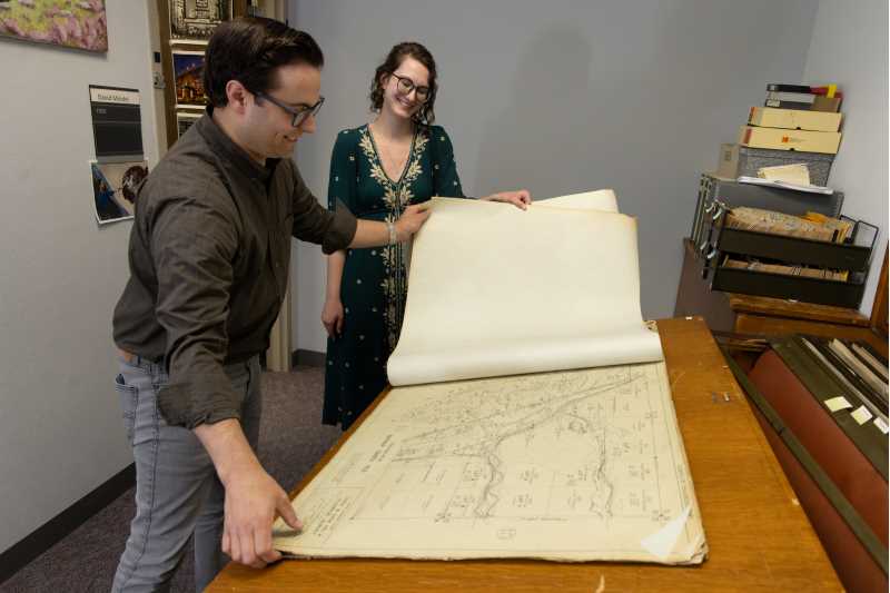 From left, David Mindel and  Nikki Pegarsch look at charts from 1932 of locks and dams on Upper Mississippi River. Collections related to the Upper Mississippi River and Driftless Area have been growing organically on the UWL campus since the university's inception.