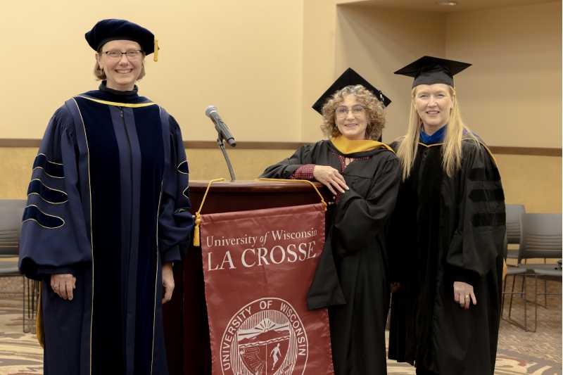 December Graduate Michele Stingl, center, pictured at the UWL Graduate Hooding Ceremony in December 2024. At left is Meredith Thomsen, dean of UWL Graduate & Extended Learning, and, at far right, Keely Rees, former academic director of the Healthcare Administration program. 