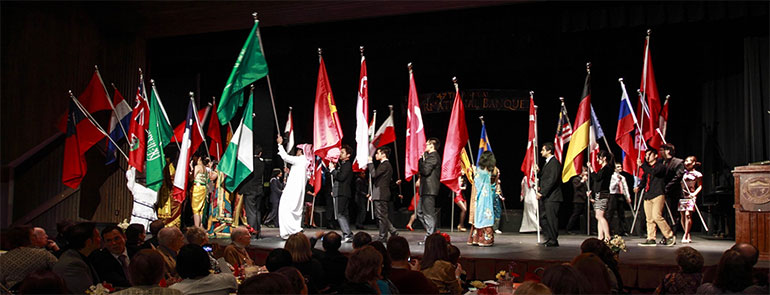 Photo of international students with flags at banquet.