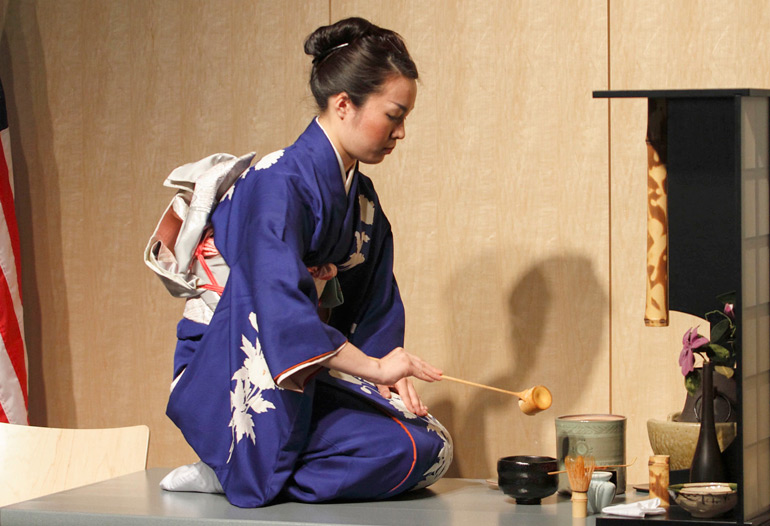 Asian woman performing tea ceremony.