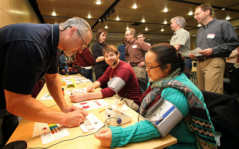 Dennis Kline measuring Vang's blood pressure.