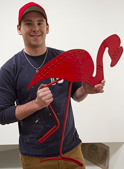 Mike holding metal flamingo. 