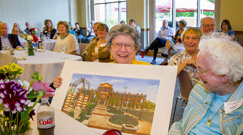 Woman holding painting.