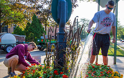 Two working on flower bed. 