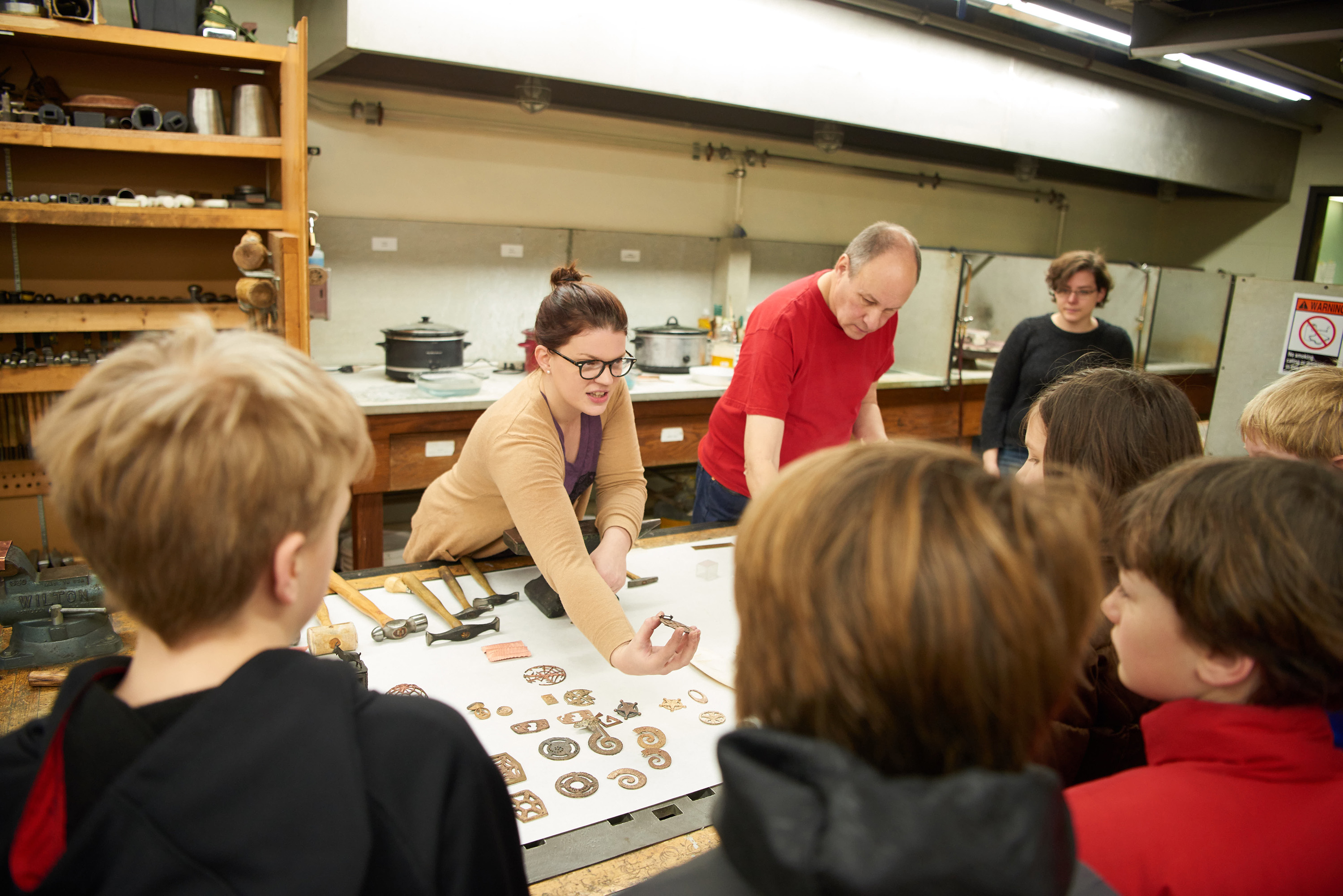 UWL student Andrea Anderson shows Emerson Elementary School, 5th graders, examples of jewelry pieces created by UWL students in the metalsmithing studio.