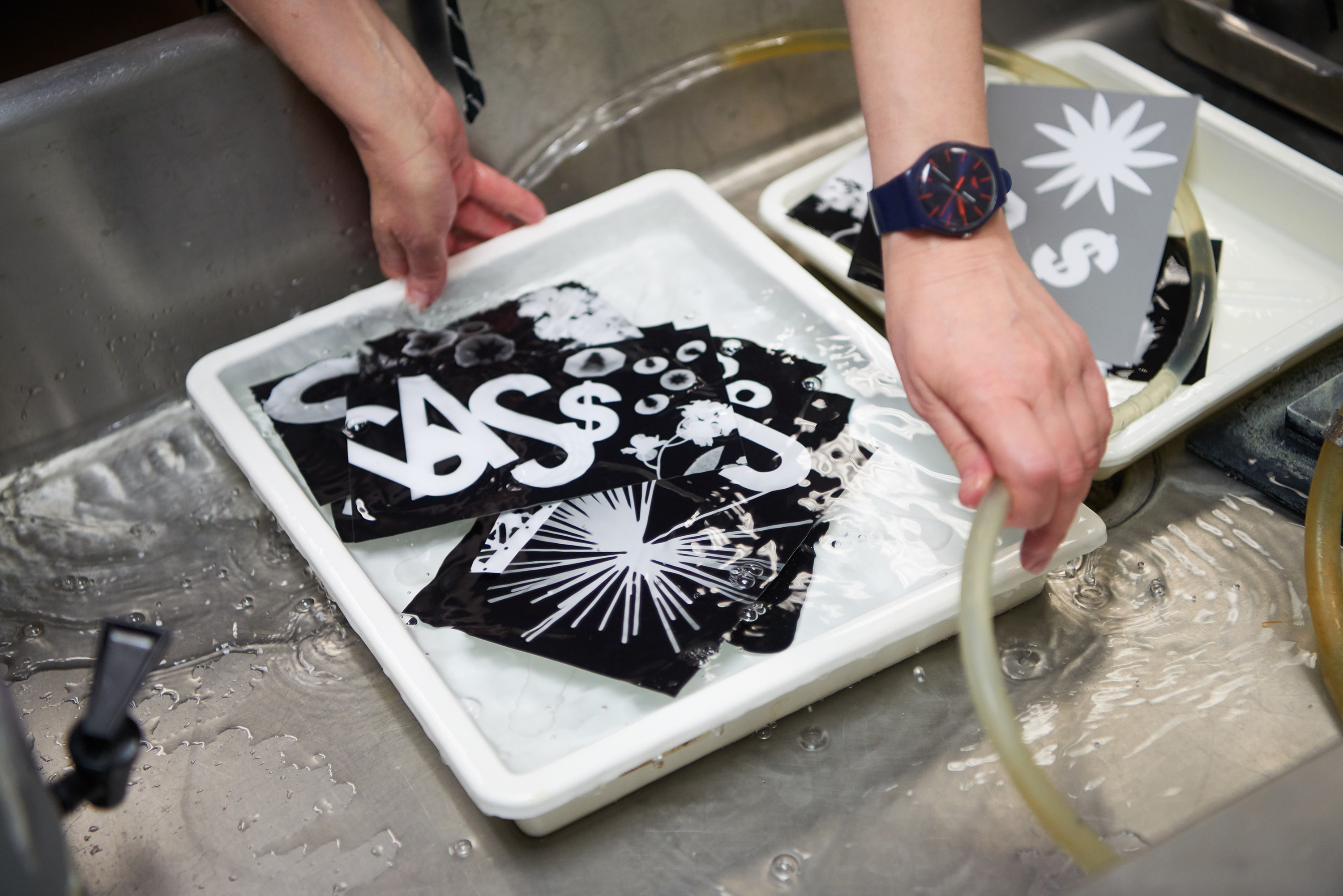 Linda Levinson, Art, washes Photogram prints in the photo lab in Wing Technology Center. Participants created Photograms, a photography technique that requires light and objects to create an image.