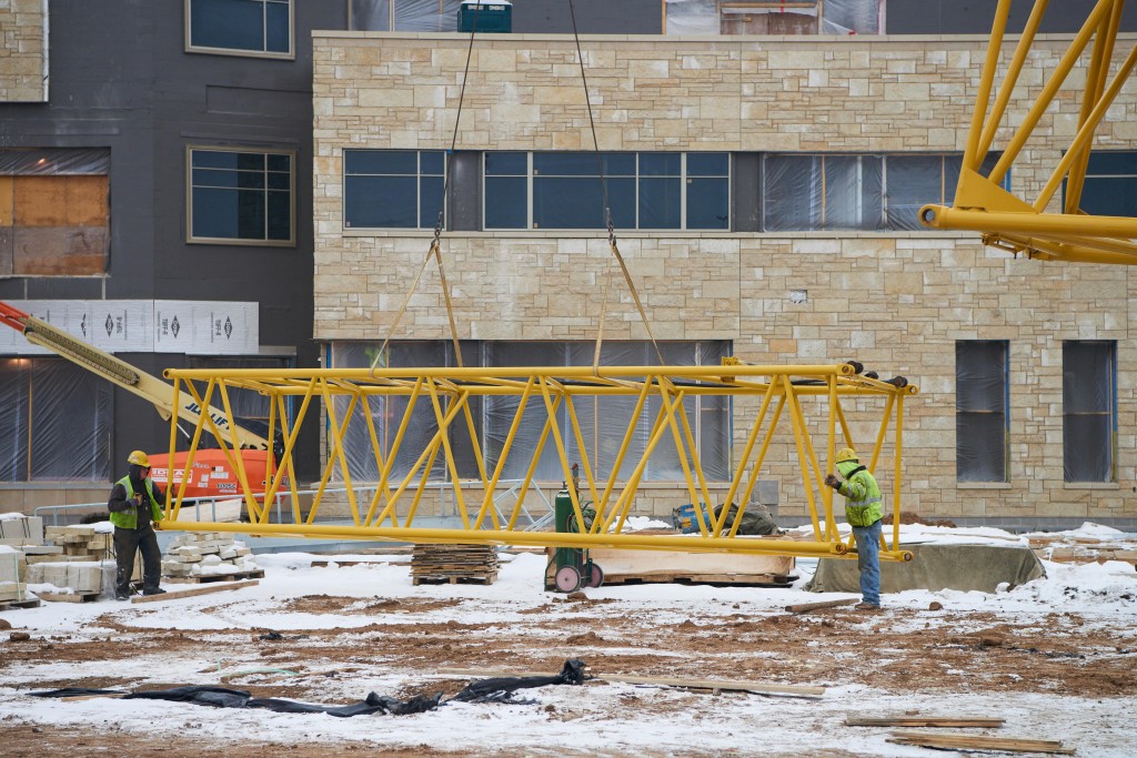 Workers disassemble one of the two cranes at the student center construction site. The projected completion time is Fall semester 2016.