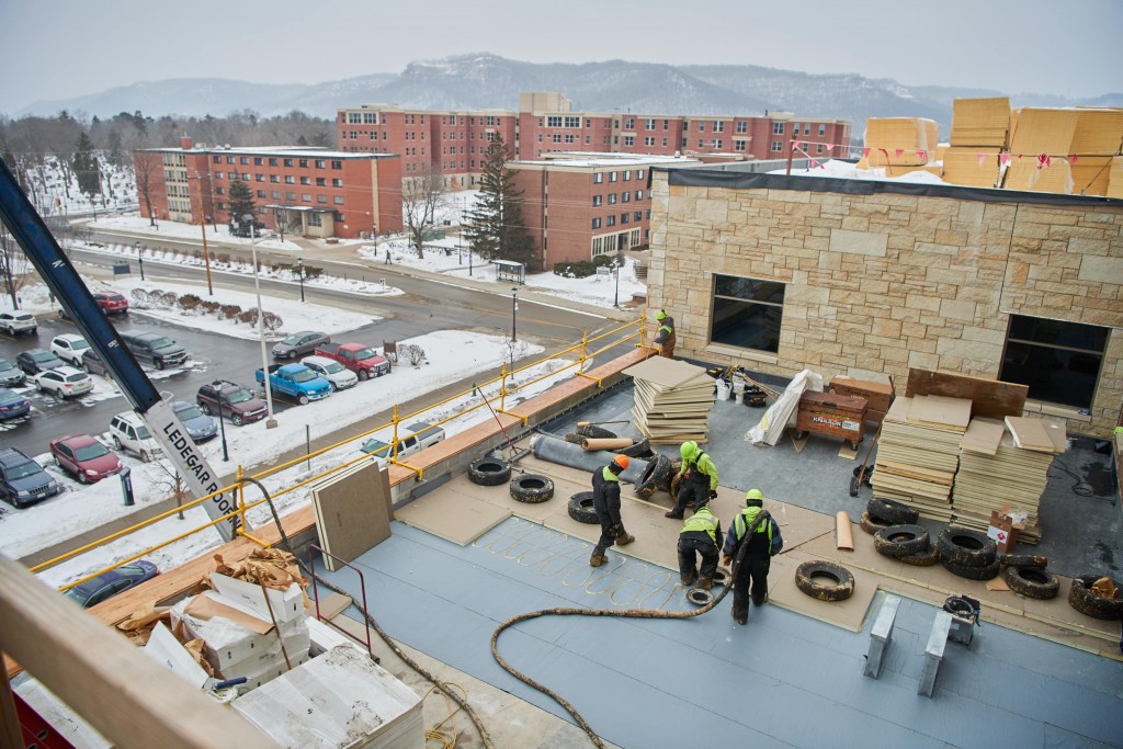 Workers place insulation on the roof of the student center. The building will incorporate a sustainable design strategy with the goal of achieving Leadership in Energy and Environmental Design Gold Certification.