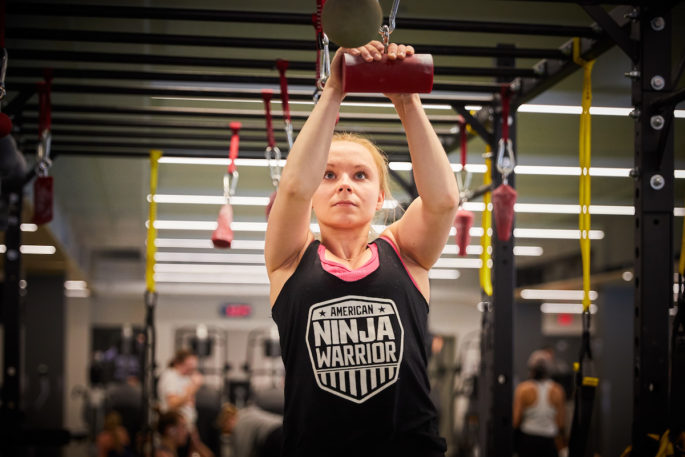 Janelle Kopa grabing a bag to hang from and swing at the REC.