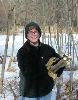 Image of Amber Miller carrying wood. 