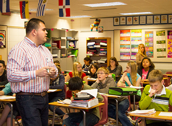 Terry Anzueto standing infront of a middle school class. 