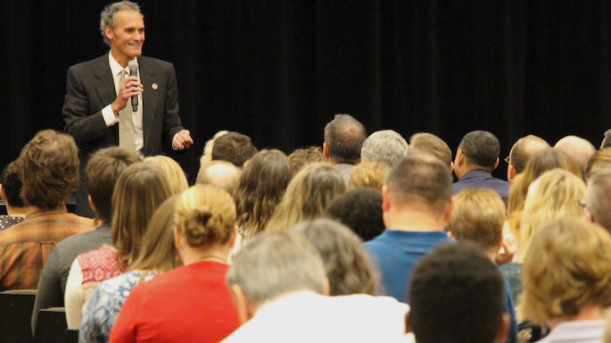 Joe Gow speaking in front of an audience in The Bluffs, Student Union.