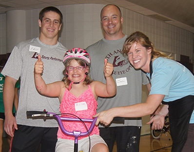 Biker with thumbs up and with three helpers.