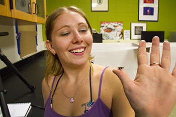 Image of Christina Burkhart holding a firefly on her thumb.