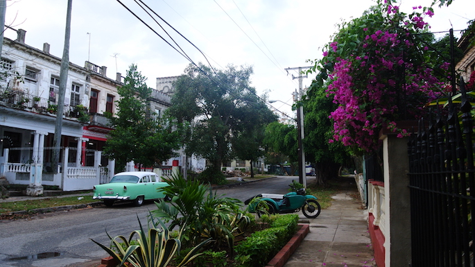 image of a street in Cuba with a classic car parked.