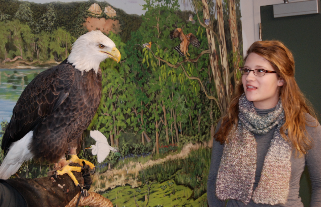 Kari Mosbacher standing next to a bald eagle. 