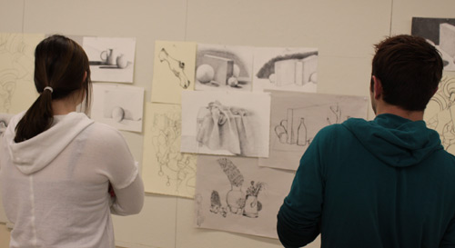 Photo of two people looking at artwork. 