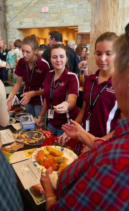 Image of people getting food at Global Initiatives Week kickoff event.