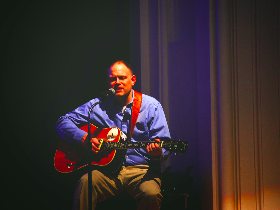 Image of Silouan Green playing guitar on stage. 