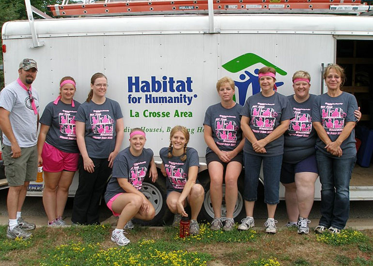 A group of employees in front of Habitat for Humanity van. 