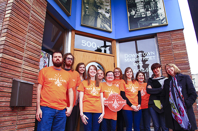 Image of students in the class and Ariel Beaujot pose in front of Downtown Mainstreet Inc. 