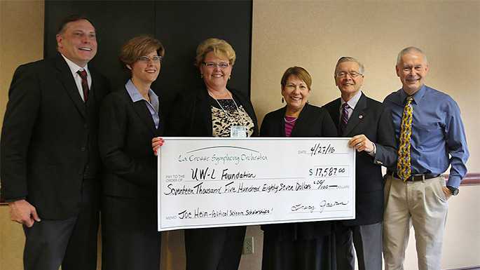 Professor Emeritus and University Legislative Liaison Joe Heim, second from right, helped raise $17,587 for political science and public administration student scholarships through the UWL Foundation as part of the La Crosse Symphony Orchestra’s 20th annual Conductor Wannabe Contest. Receiving the check with Heim are, from left, Jay Lokken, UWL Advancement; Ilene Kernozek, UWL Foundation Board of Directors; Sandra Sieber, UWL Advancement; Patricia Heim; and Jim Jorstad, UWL Information Technology and UWL Foundation Board member.