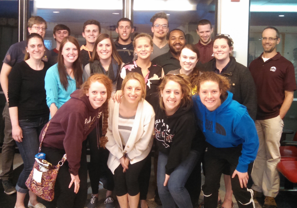 Image of a group of students by an airport window. 