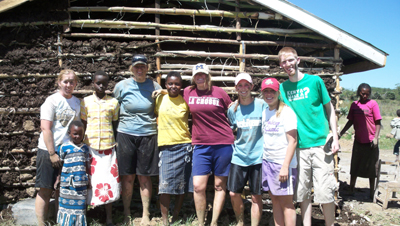 Wilson and the seven other college student volunteers stand in front of the half built classroom they helped build for Kenyan kids at Soar-Kenya Academy