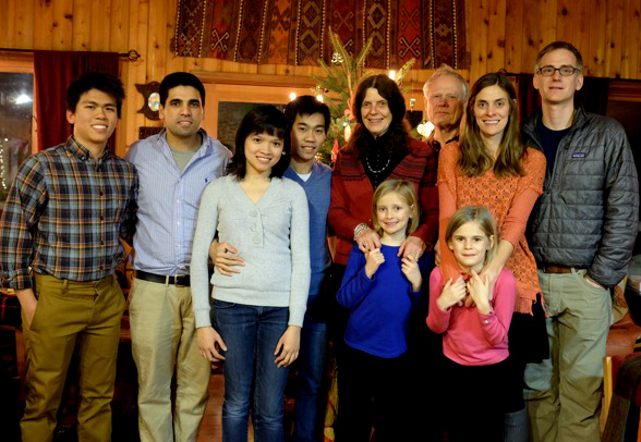 Image of the Lisbeth REynertson family and four international students standing infront of a Christmas tree in the Reynertson home. 