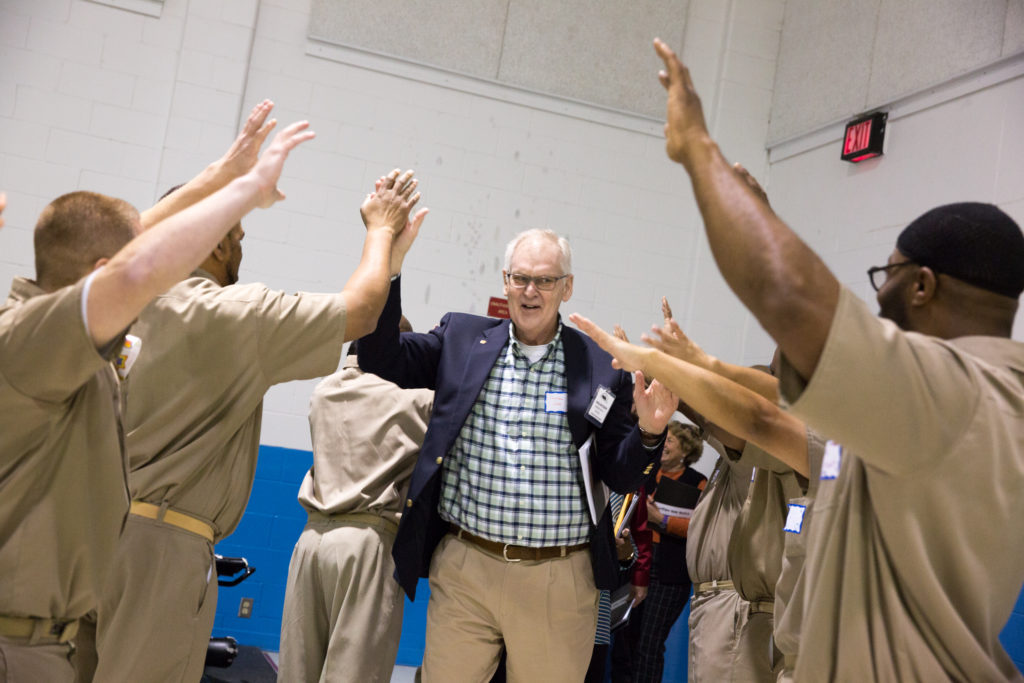 Joe Kastantin giving high fives to participants in the Defy Ventures program.