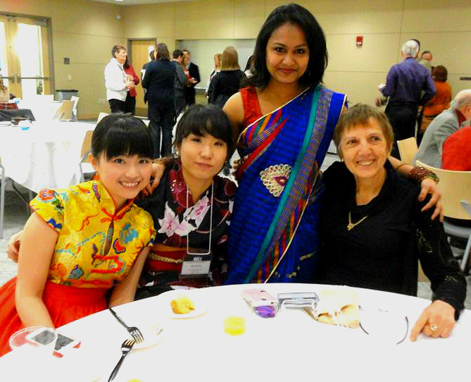 UW-L graduate Peiqing Chen pictured sitting at a table with others at the 2013 International Banquet. 