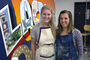 Kienzle and Pleshe pose for the camera next to their mural.