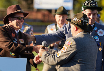 Image of Brad Quarberg taking the microphone from the current Oktoberfest president. 