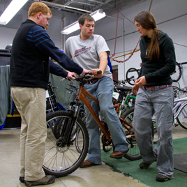 UW-L graduate student Jarod Meyer tries out a bike at Outdoor Connection as staff, Anna DeMers, right and Nathan Barnhart, left, help out.