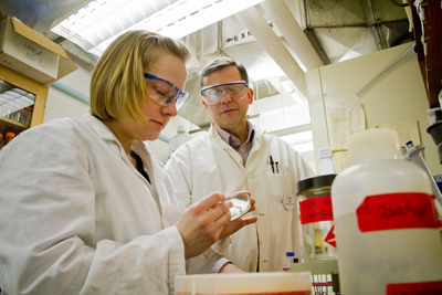Biology Professor Mike Winfrey supervises as Kristen Zimmerman applies Hickory compounds to a bacteria sample.