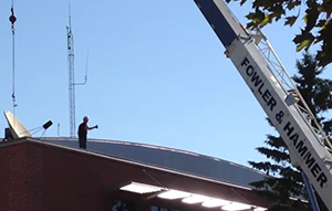 Image of a satellite dish going up on the top of the Wing Technology Center.