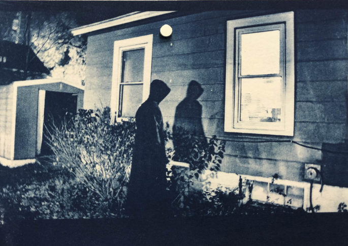 Cyanotype image of man outside window.