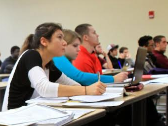 Image of students sitting at desks taking notes. 