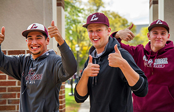 Three students in UW-L sweatshirts giving a thumbs up. 