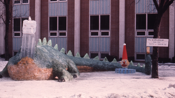 Image of a giant dragon made of snow and died greeen outside of UWL building.