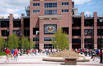 Image of Veterans Memorial Field Sports Complex with people walking outside. 