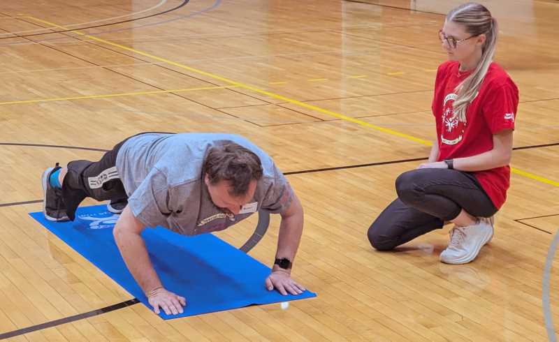 UWL students engaged with athletes at various stations, measuring physical fitness data.